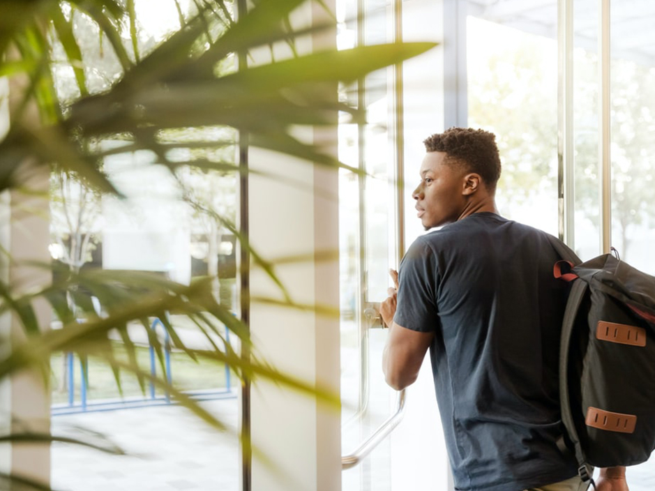 Étudiant sortant de l'ÉTS avec son sac à dos bien rempli